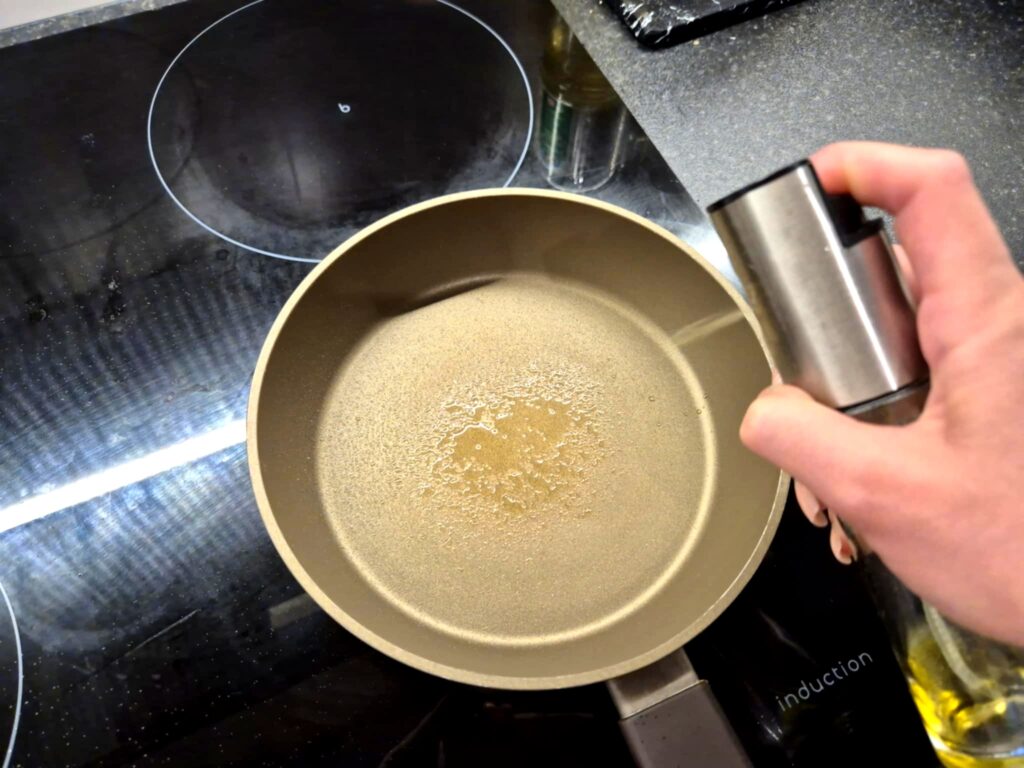 Natłuszczona patelnia oliwą w sprayu, gotowa do smażenia boczku.